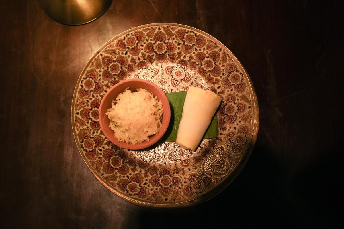 a plate with a bowl of rice and a piece of tofu at Haveli Dharampura & Golden Haveli- UNESCO awarded Boutique Heritage Hotel in New Delhi a plate with a bowl of rice and a piece of tofu at Haveli Dharampura & Golden Haveli- UNESCO awarded Boutique Heritage Hotel in New Delhi