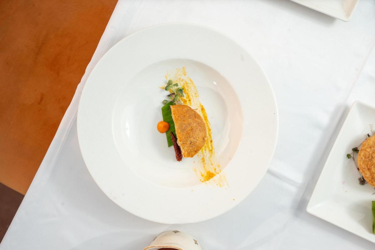 a white plate with food on a table at Haveli Dharampura & Golden Haveli- UNESCO awarded Boutique Heritage Hotel in New Delhi a white plate with food on a table at Haveli Dharampura & Golden Haveli- UNESCO awarded Boutique Heritage Hotel in New Delhi