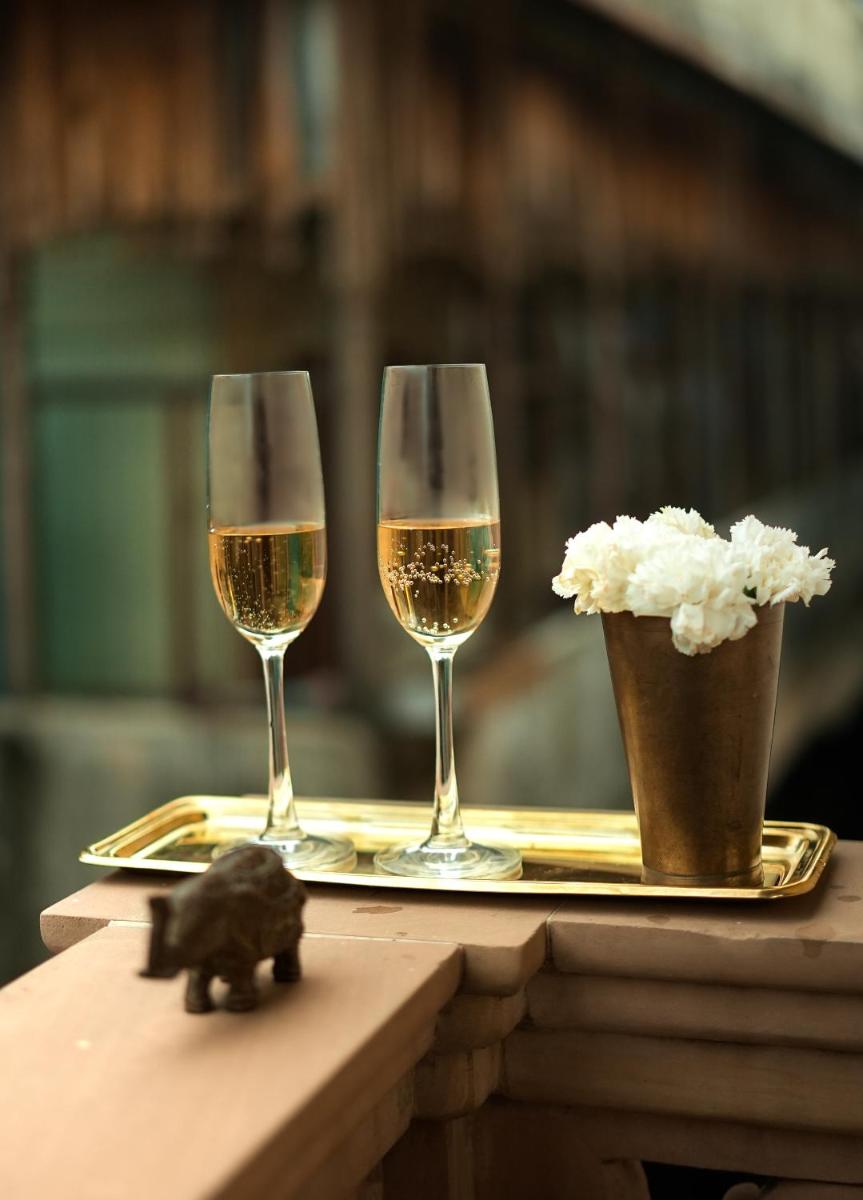 two glasses of wine on a tray on a table at Haveli Dharampura & Golden Haveli- UNESCO awarded Boutique Heritage Hotel in New Delhi two glasses of wine on a tray on a table at Haveli Dharampura & Golden Haveli- UNESCO awarded Boutique Heritage Hotel in New Delhi