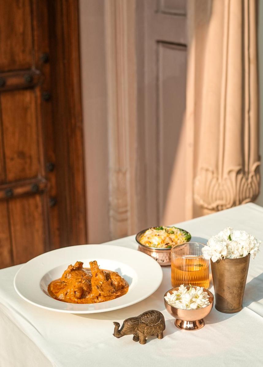 a table with two plates of food on it at Haveli Dharampura & Golden Haveli- UNESCO awarded Boutique Heritage Hotel in New Delhi a table with two plates of food on it at Haveli Dharampura & Golden Haveli- UNESCO awarded Boutique Heritage Hotel in New Delhi