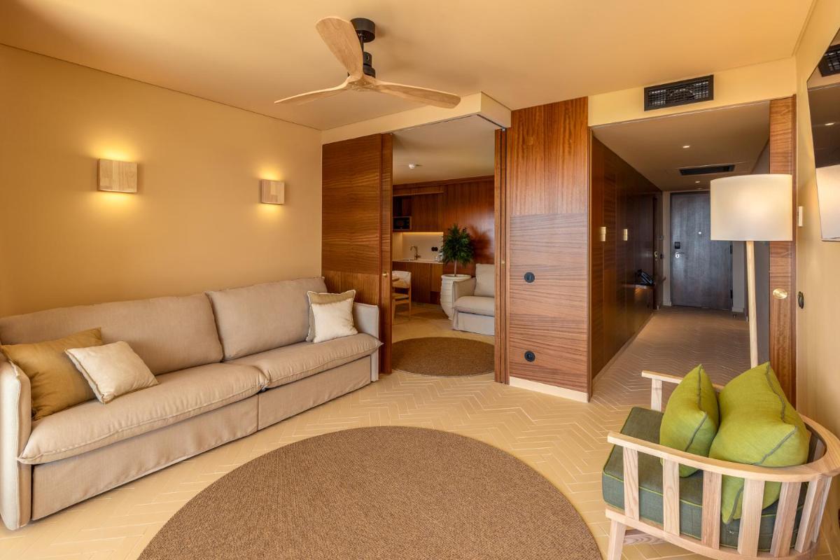 uma sala de estar com um sofá e um quarto em 3HB Falesia Beach em Albufeira