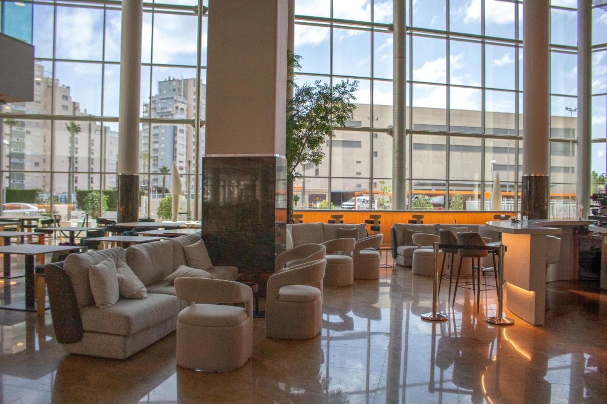 un vestíbulo con sofás y sillas en un edificio con ventanas en AR Diamante Beach & SPA Hotel 4 SUP, en Calpe