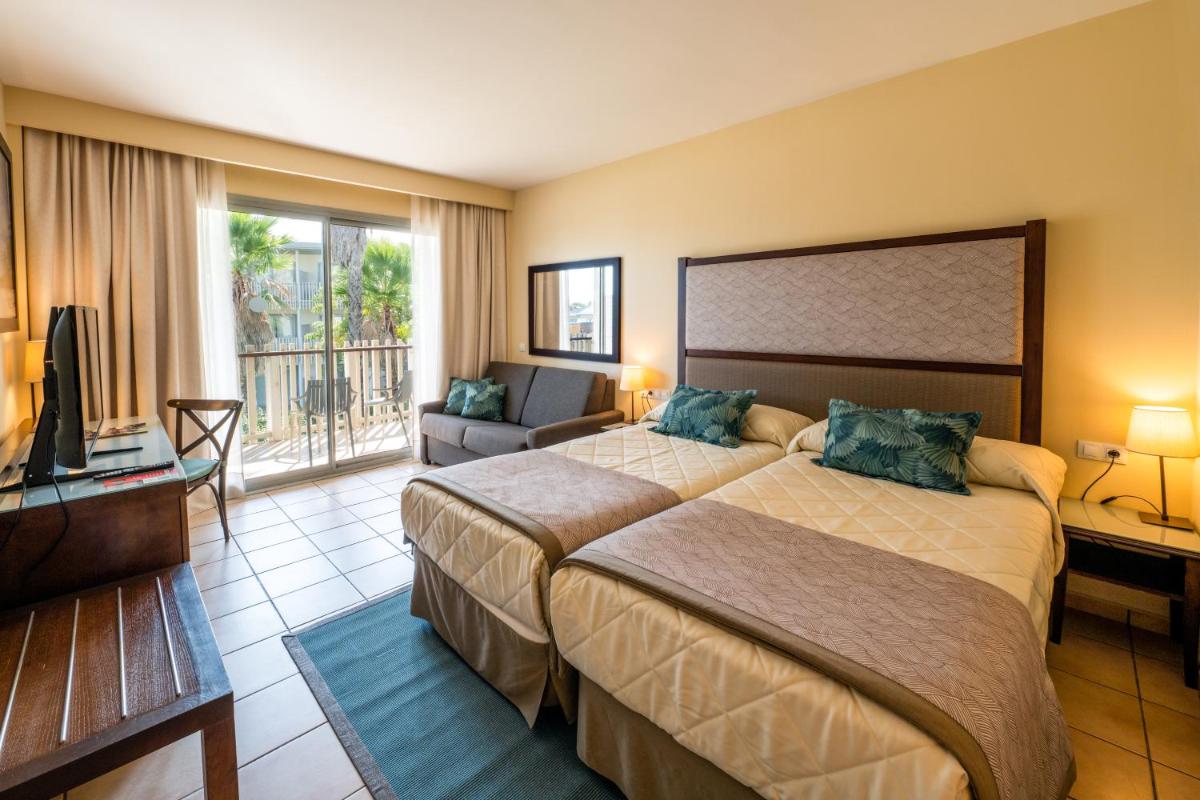 Una habitación de hotel con dos camas y un televisor. en PortAventura Hotel Caribe - Includes unlimited access to PortAventura Park & 1 access to Ferrari Land, en Salou