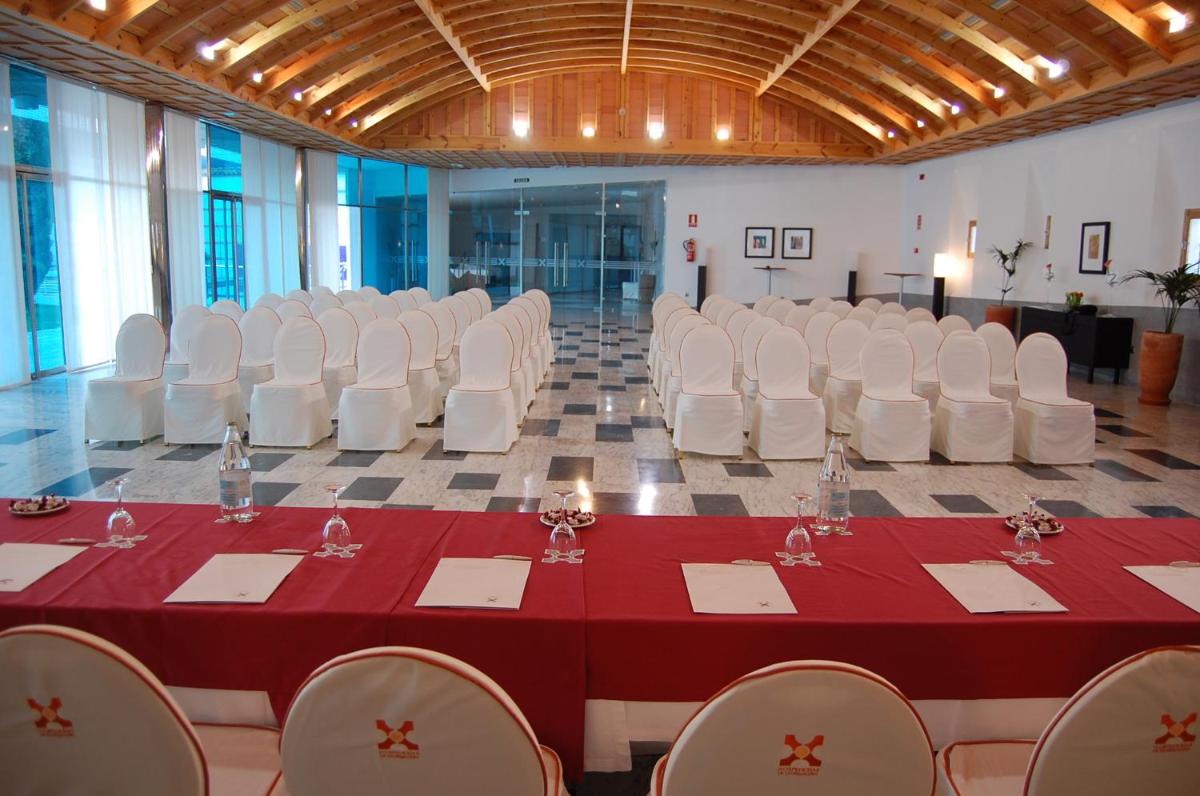 una sala de conferencias con mesa y sillas blancas en Hotel Mirador de Llerena, en Llerena 102 fotos más