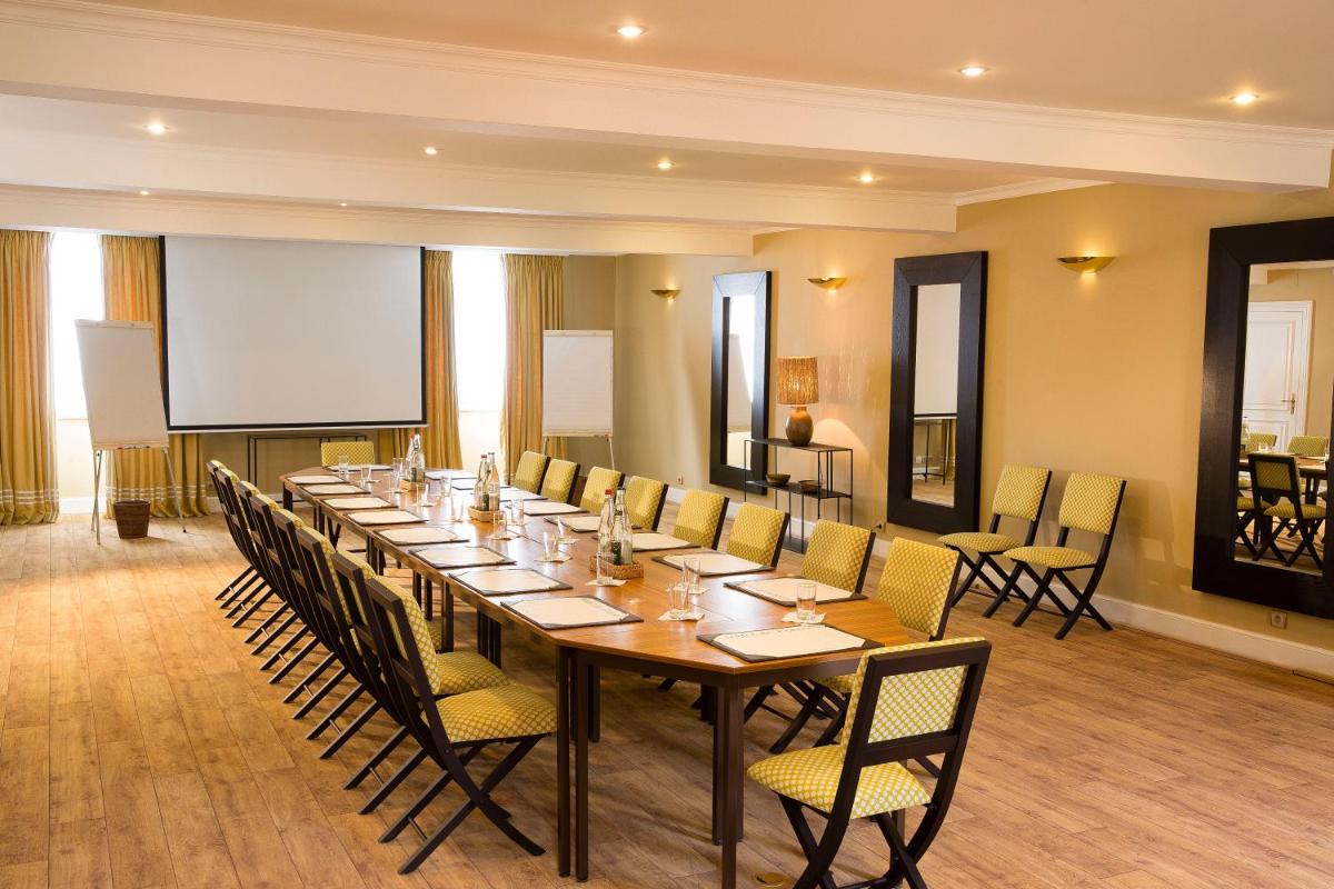 une grande salle de conférence avec une longue table et des chaises dans l'établissement Hotel De France, à Angerville 59 autres photos