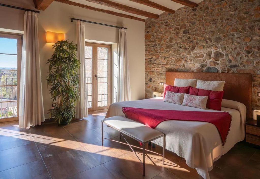 Un dormitorio con una cama y una pared de piedra. en Cal Barber, en Botarell