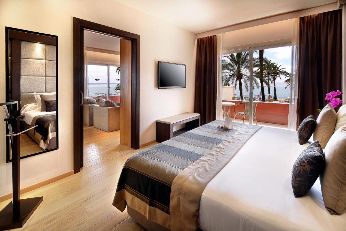 Un dormitorio con una cama grande y una sala de estar. en Palace Bonanza Playa Resort & SPA by Olivia Hotels Collection, en Illetas