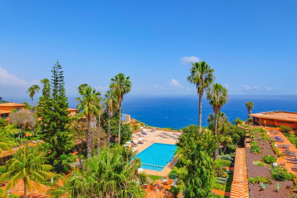 uma vista aérea de um resort com piscina e o oceano em Quinta Splendida Wellness & Botanical Garden no Caniço