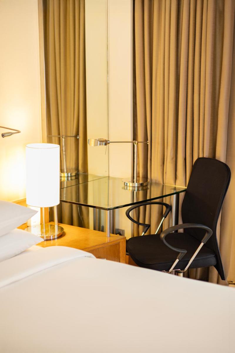 a bedroom with a bed and a glass table and chairs at Hyatt Hyderabad Gachibowli in Hyderabad