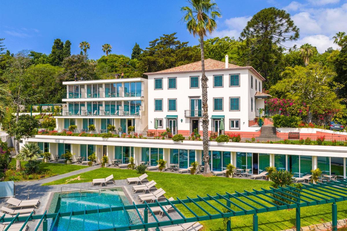 uma vista exterior de um grande edifício branco com uma piscina em Pestana Quinta Perestrello no Funchal