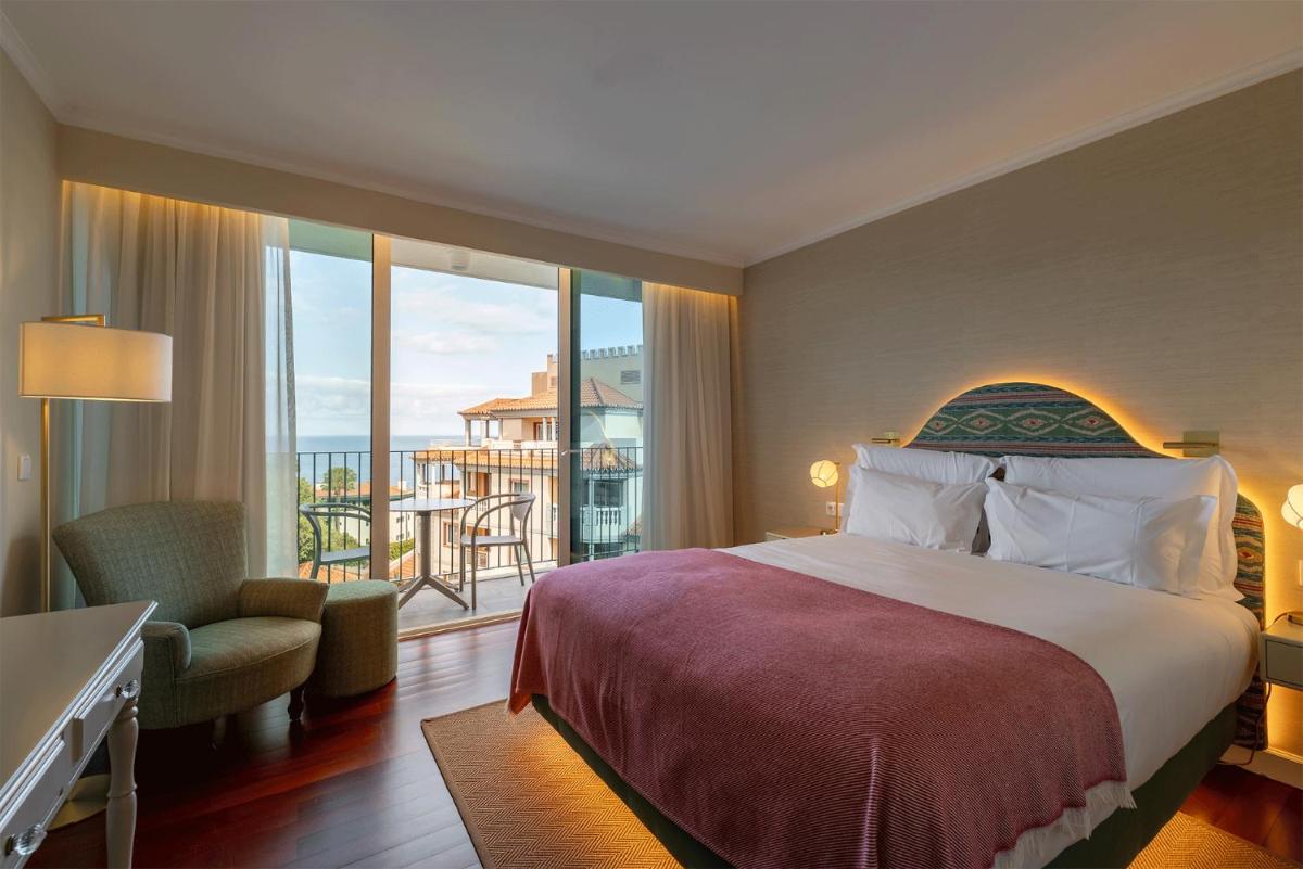 um quarto de hotel com uma cama e uma varanda em Pestana Quinta Perestrello no Funchal