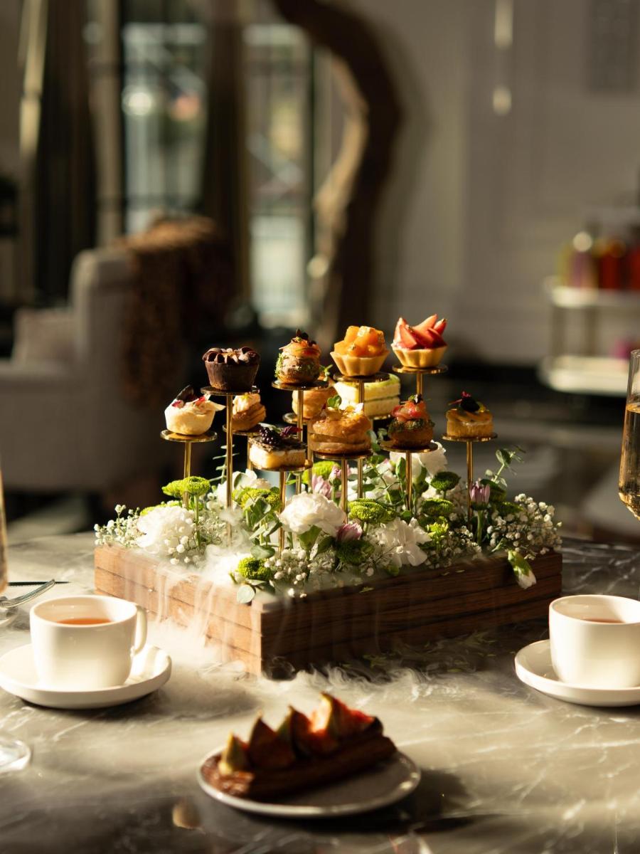 a display of pastries on a table with cups of coffee at Fairmont Mumbai in Mumbai