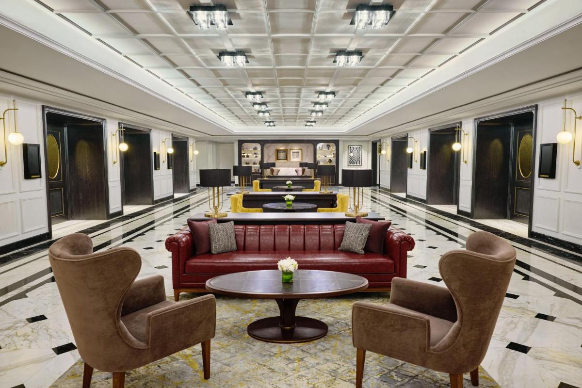 a lobby with a couch and two chairs and a table at Fairmont Mumbai in Mumbai