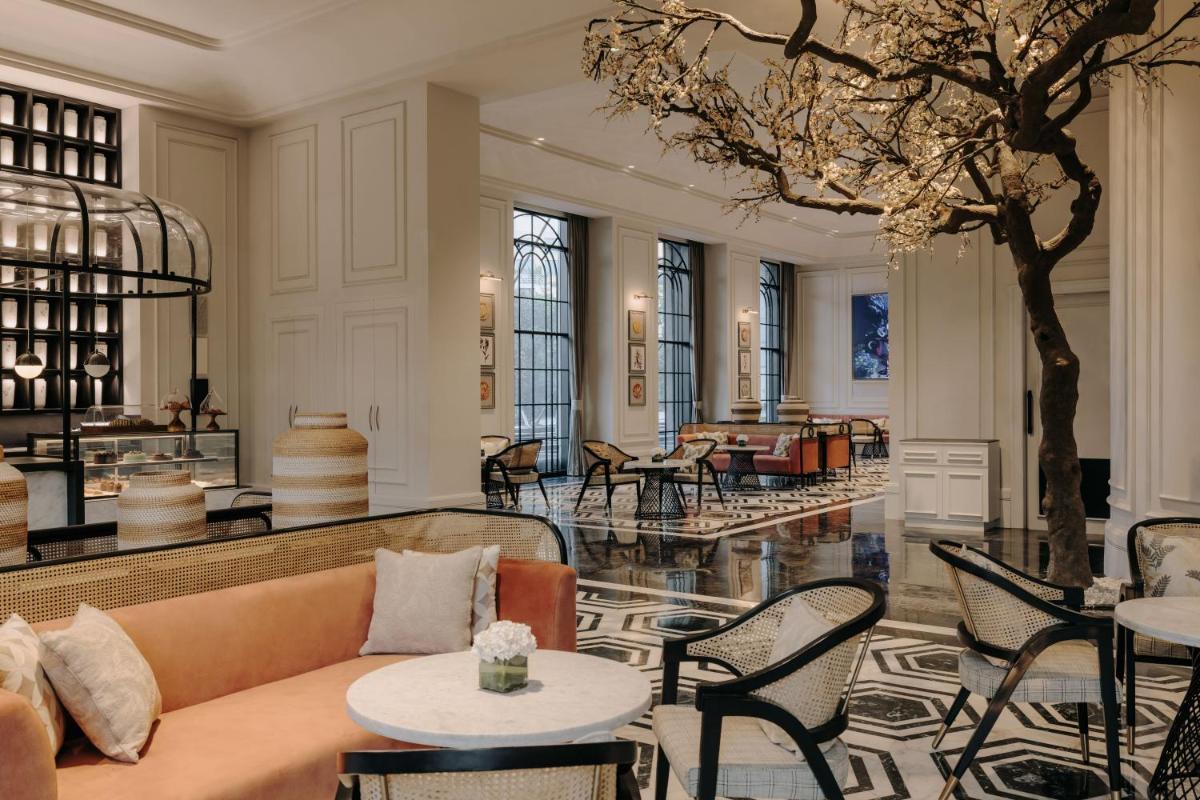 a lobby with a couch and tables and a piano at Fairmont Mumbai in Mumbai