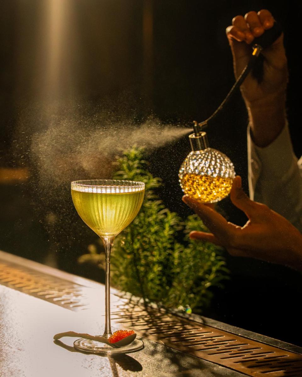 a person washing a wine glass on a table at Fairmont Mumbai in Mumbai