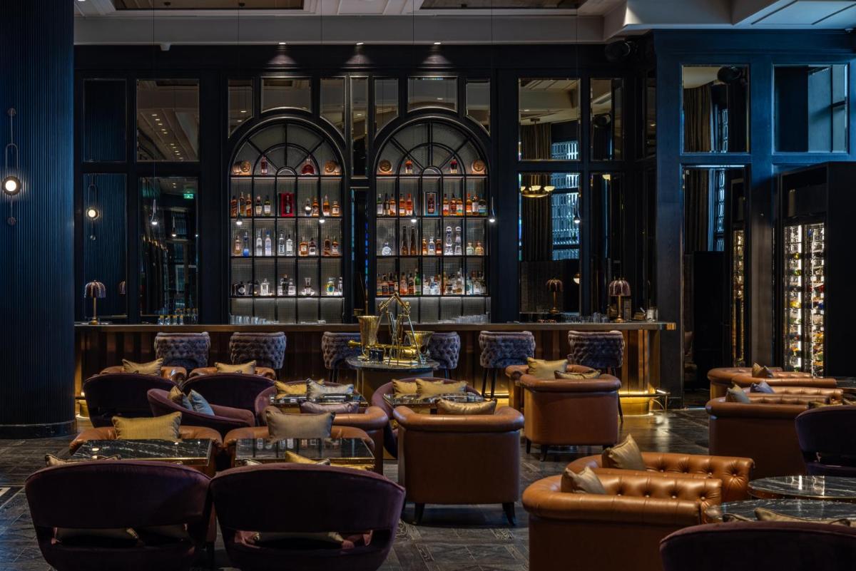 a bar with couches and tables in a room at Fairmont Mumbai in Mumbai