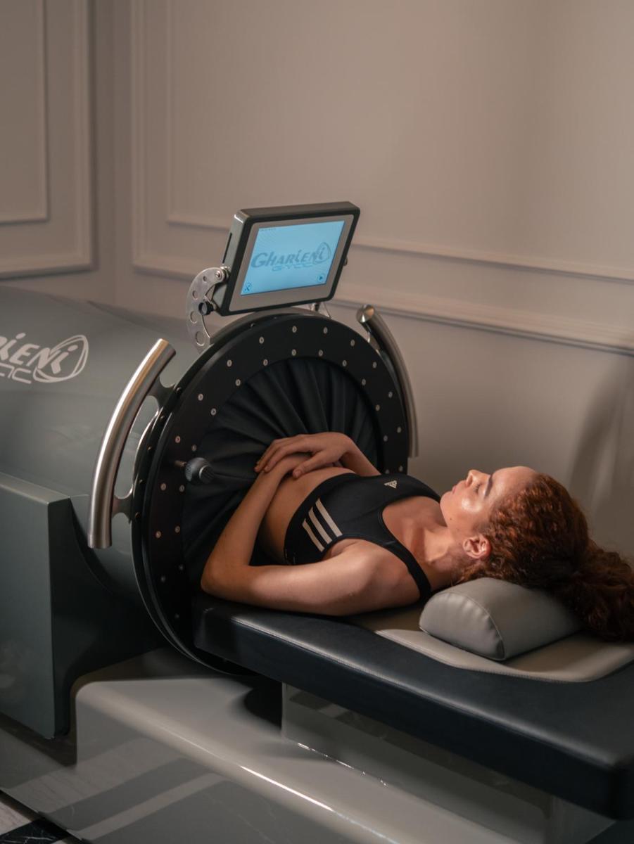 a woman laying on a bed in a machine at Fairmont Mumbai in Mumbai