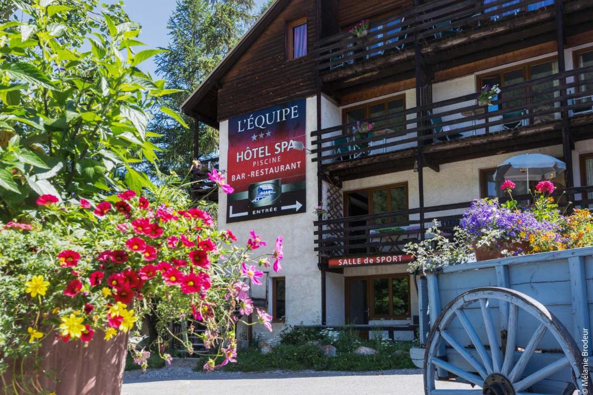 un hôtel avec des fleurs devant un bâtiment dans l'établissement Hotel Spa L'Equipe, à Molines-en-Queyras