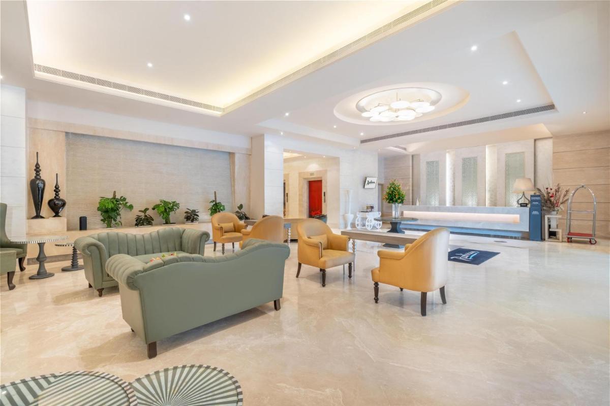a large lobby with couches and chairs in a room at Radisson Hyderabad Hitec City in Hyderabad