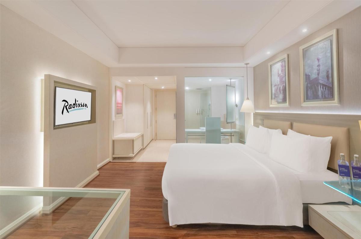 a hotel room with a large white bed in a room at Radisson Hyderabad Hitec City in Hyderabad