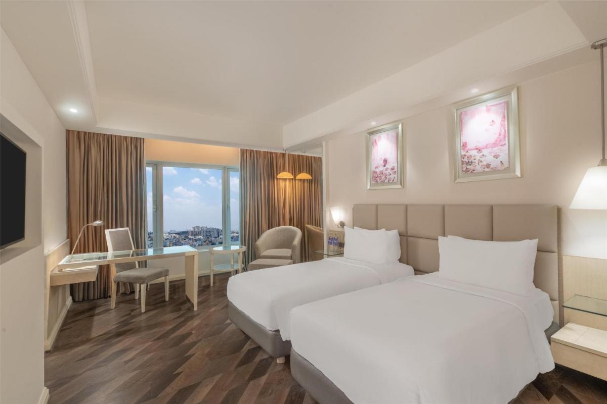a hotel room with two beds and a desk at Radisson Hyderabad Hitec City in Hyderabad