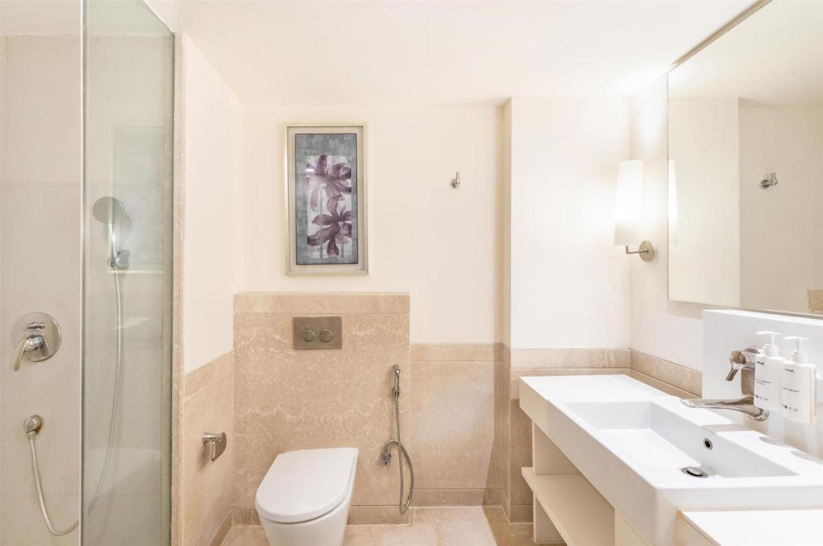a bathroom with a toilet sink and a shower at Radisson Hyderabad Hitec City in Hyderabad