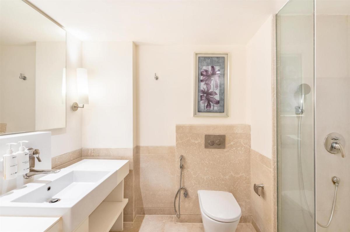 a bathroom with a sink and a toilet and a shower at Radisson Hyderabad Hitec City in Hyderabad