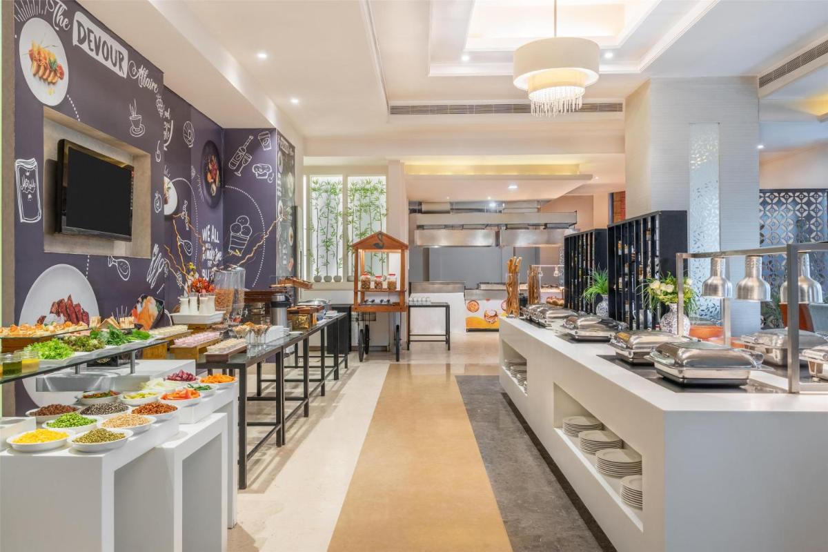 a restaurant with a buffet of food on display at Radisson Hyderabad Hitec City in Hyderabad