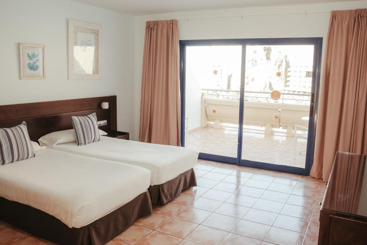 Una habitación de hotel con dos camas y balcón. en Hotel LIVVO Lago Taurito & Aquapark, en Taurito