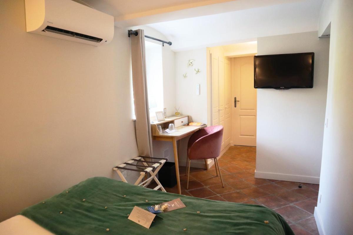 une chambre avec un lit, un bureau et une table dans l'établissement Le Domaine Du Colombier, à Malataverne