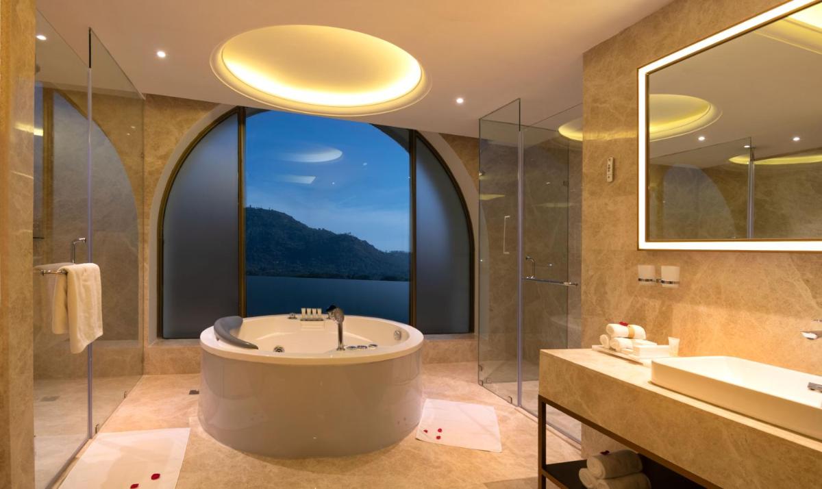 a bathroom with a tub and a large window at Radisson Blu Plaza Hotel Mysore in Mysore