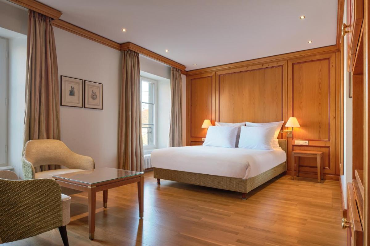 une chambre d'hôtel avec un lit, une chaise et une table dans l'établissement Hotel & Spa A la cour d'Alsace by HappyCulture, à Obernai