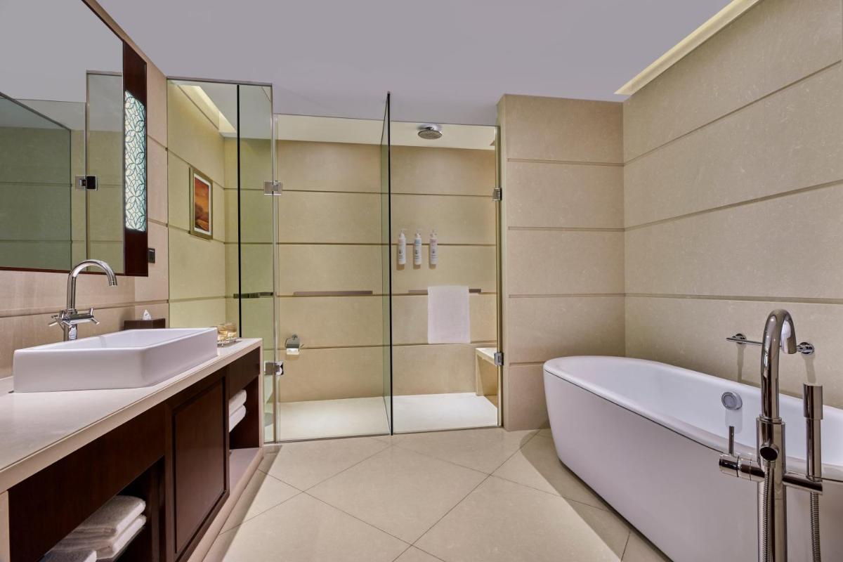 a bathroom with a tub and a sink and a shower at Kochi Marriott Hotel in Cochin