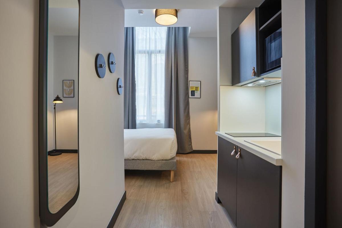 Un ou plusieurs lits dans un hébergement de l'établissement Appart'hôtel Odalys City - Nîmes Arènes - Palais des Congrès