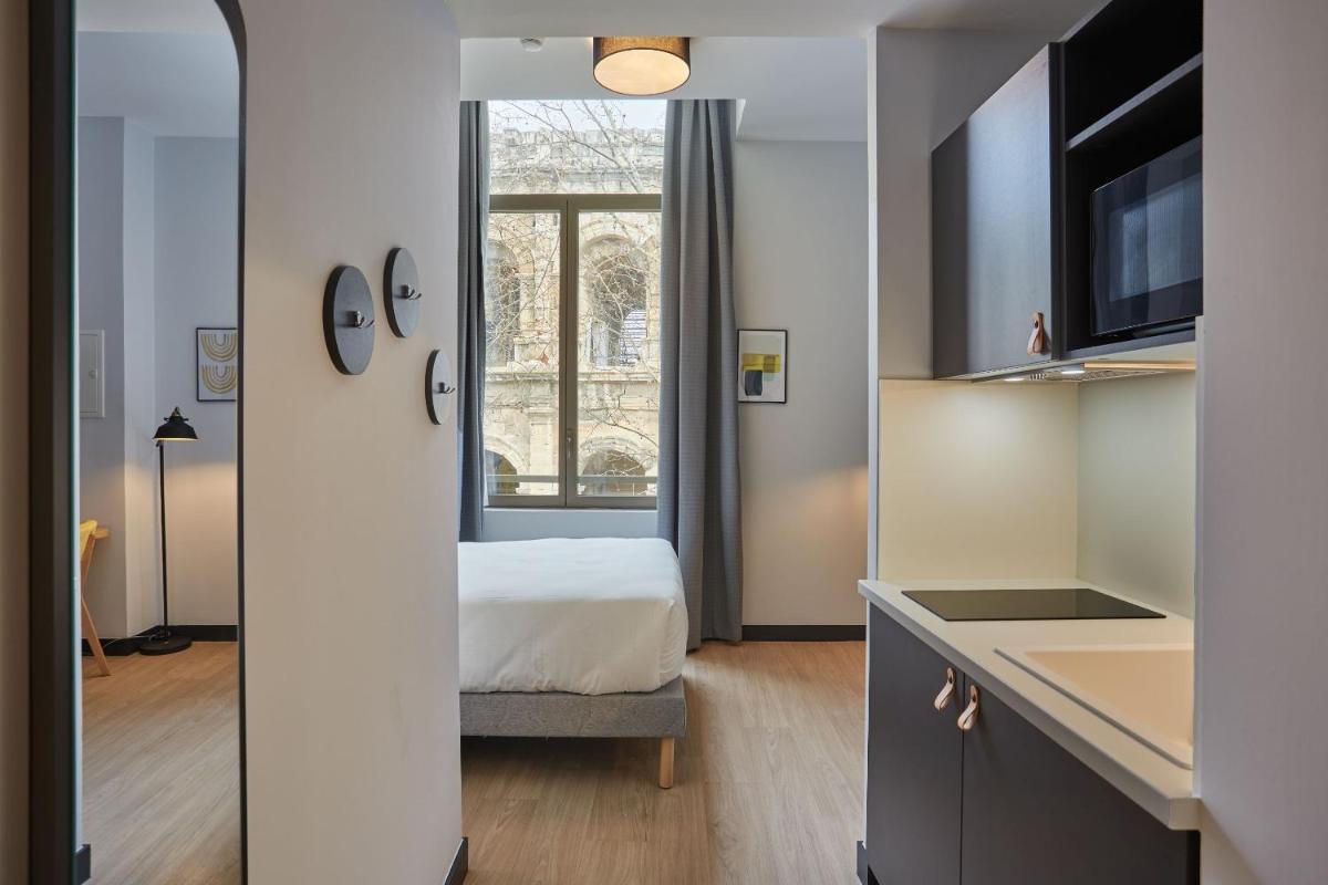Un ou plusieurs lits dans un hébergement de l'établissement Appart'hôtel Odalys City - Nîmes Arènes - Palais des Congrès