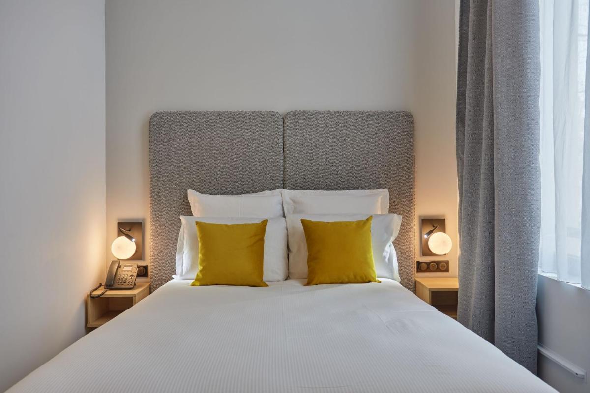 Un ou plusieurs lits dans un hébergement de l'établissement Appart'hôtel Odalys City - Nîmes Arènes - Palais des Congrès