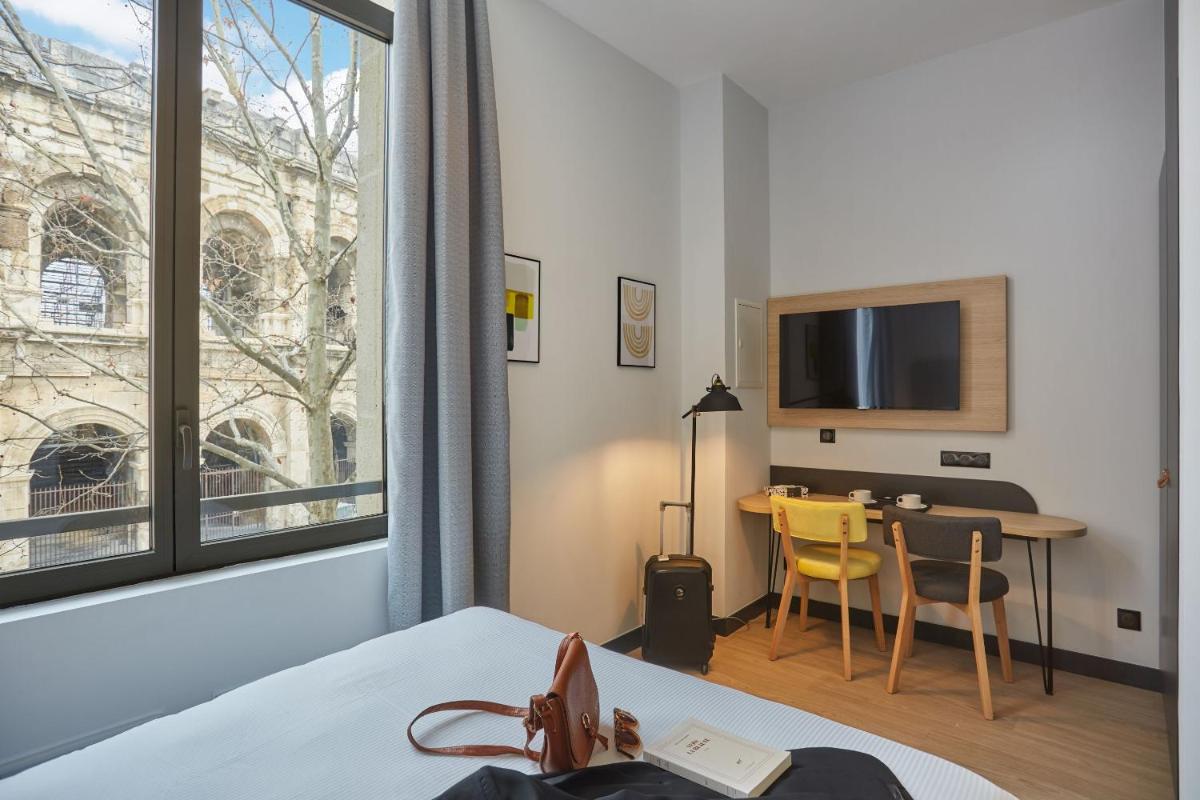 Un ou plusieurs lits dans un hébergement de l'établissement Appart'hôtel Odalys City - Nîmes Arènes - Palais des Congrès