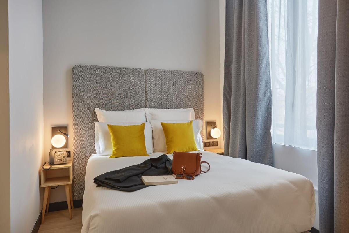 Un ou plusieurs lits dans un hébergement de l'établissement Appart'hôtel Odalys City - Nîmes Arènes - Palais des Congrès
