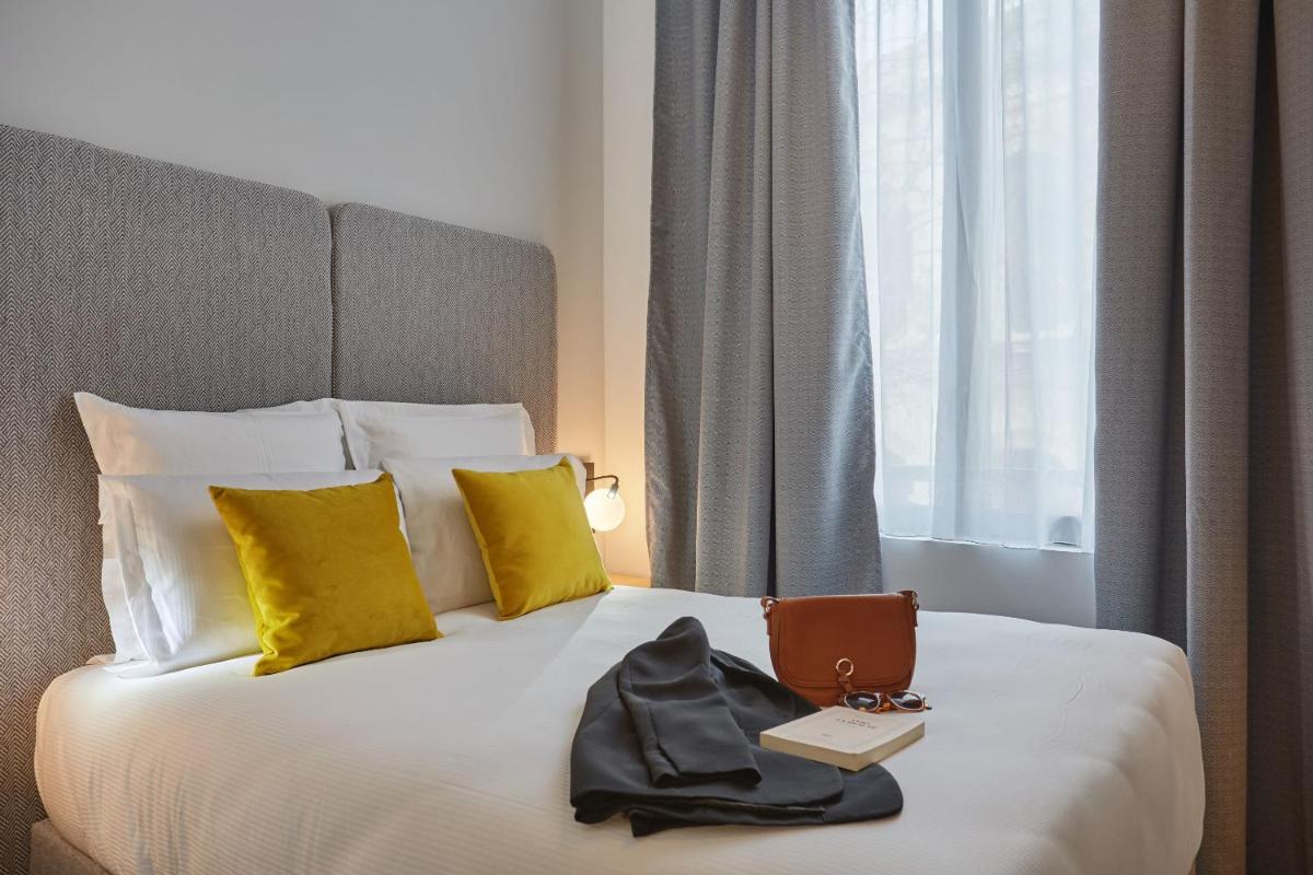 Un ou plusieurs lits dans un hébergement de l'établissement Appart'hôtel Odalys City - Nîmes Arènes - Palais des Congrès