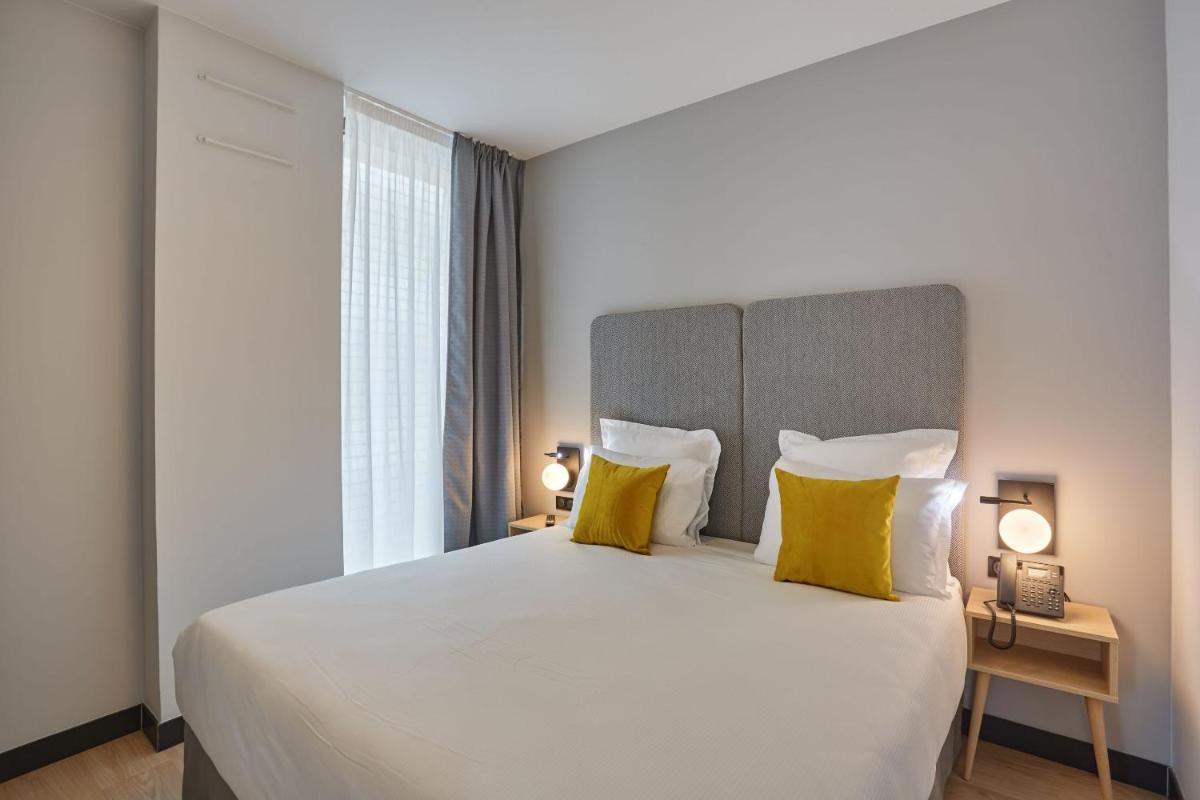 Un ou plusieurs lits dans un hébergement de l'établissement Appart'hôtel Odalys City - Nîmes Arènes - Palais des Congrès