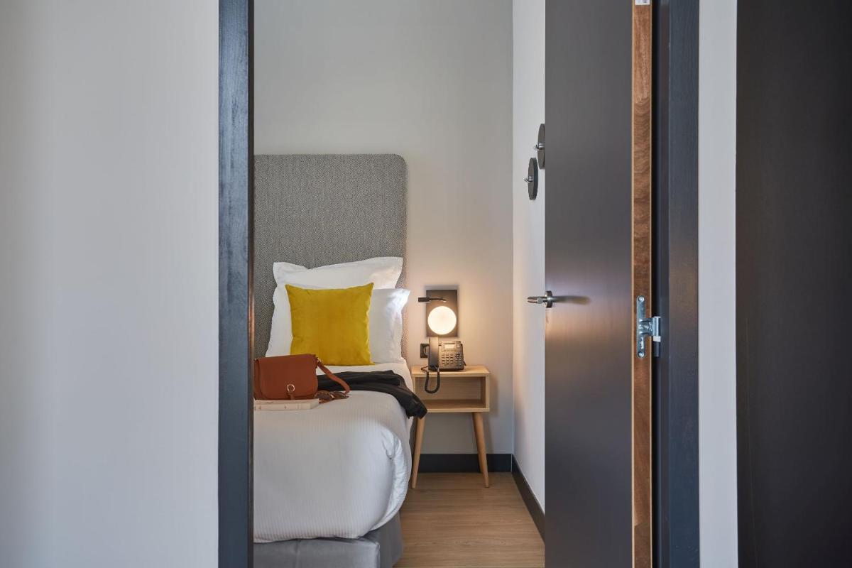 Un ou plusieurs lits dans un hébergement de l'établissement Appart'hôtel Odalys City - Nîmes Arènes - Palais des Congrès
