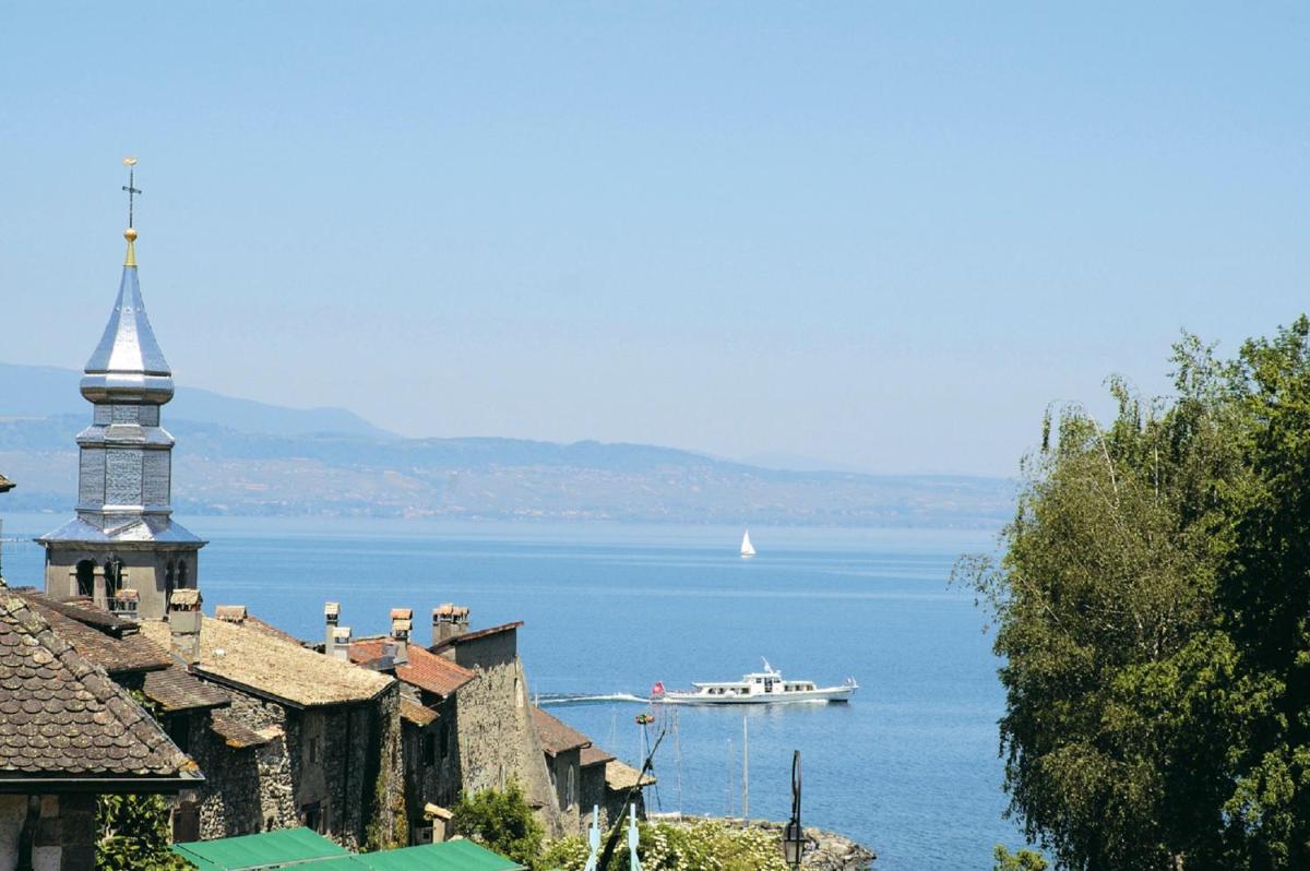 un bateau dans une grande étendue d'eau dans l'établissement Le Pré de la Cure, à Yvoire