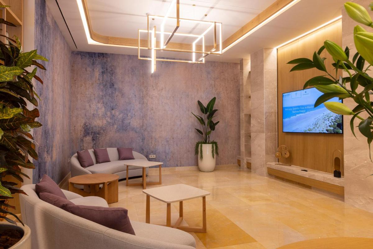 Una sala de estar con un sofá y un televisor. en Hipotels Barrosa Palace & Spa, en Chiclana de la Frontera
