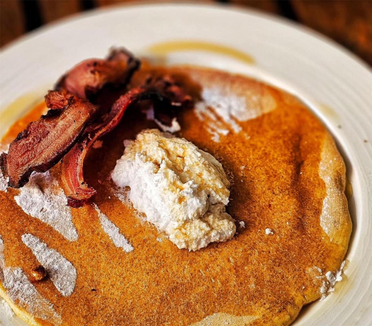 a plate of pancakes with bacon and powdered sugar at Radisson Blu Mumbai International Airport in Mumbai a plate of pancakes with bacon and powdered sugar at Radisson Blu Mumbai International Airport in Mumbai