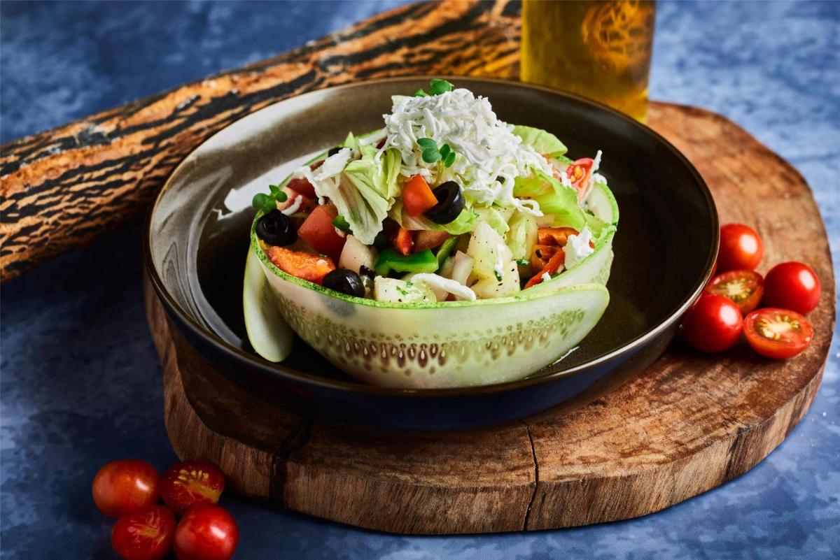 a salad in a black bowl on a wooden cutting board at Radisson Blu Mumbai International Airport in Mumbai a salad in a black bowl on a wooden cutting board at Radisson Blu Mumbai International Airport in Mumbai