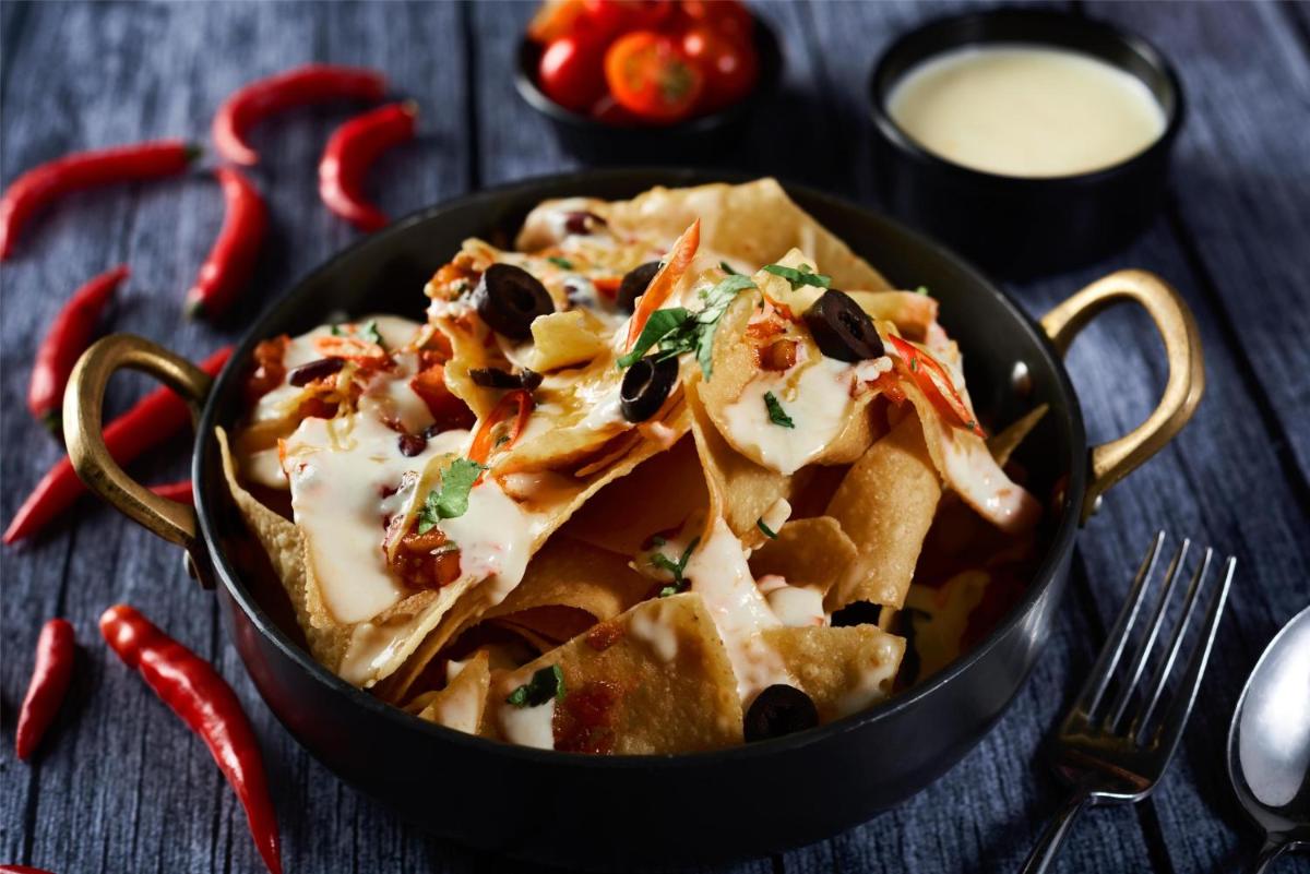 a black pan filled with nachos with toppings at Radisson Blu Mumbai International Airport in Mumbai a black pan filled with nachos with toppings at Radisson Blu Mumbai International Airport in Mumbai