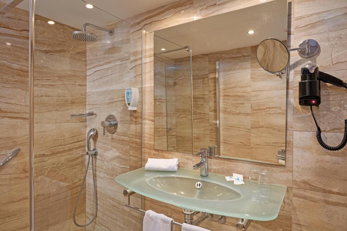 un baño con lavabo y ducha en Grupotel Port D´Alcudia, en Puerto de Alcudia