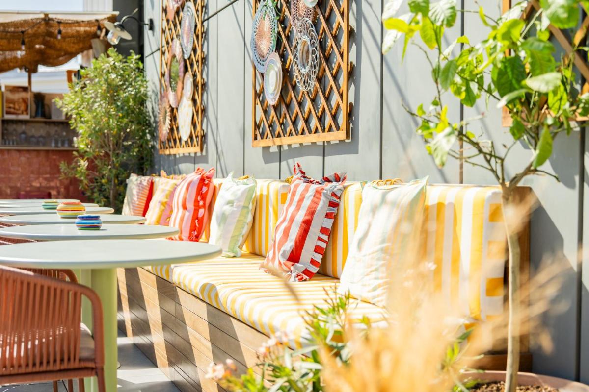 un canapé avec des coussins sur une terrasse avec une table dans l'établissement Quinzerie hôtel, à Paris