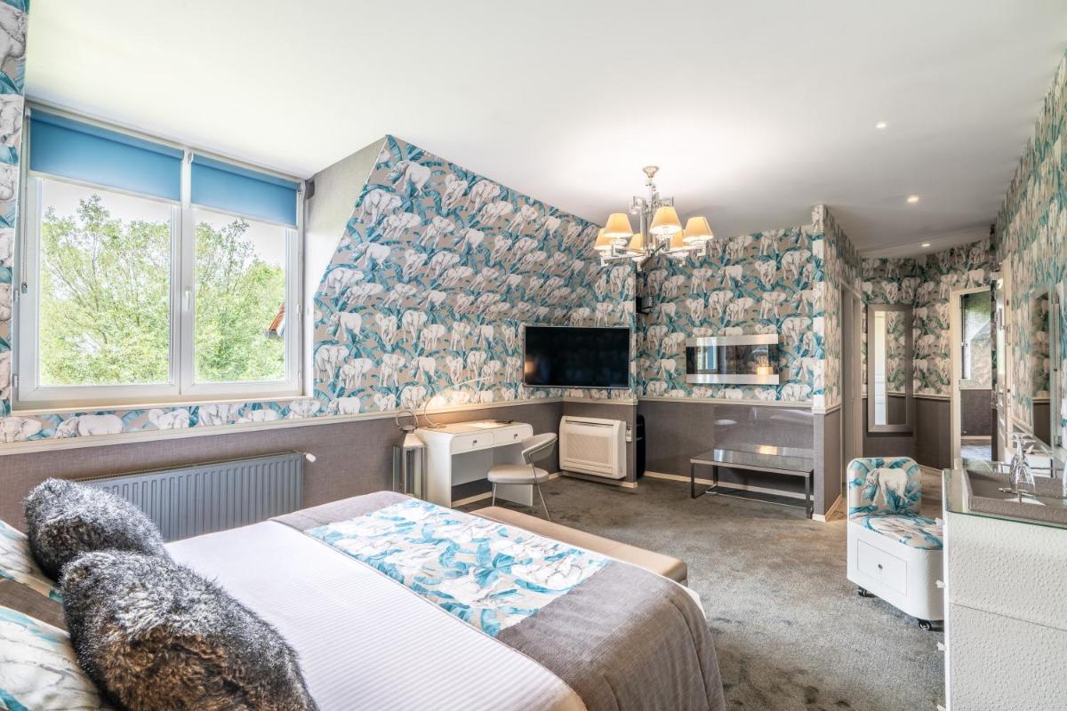 Télévision ou salle de divertissement dans l'établissement Le Manoir De La Poterie & Spa