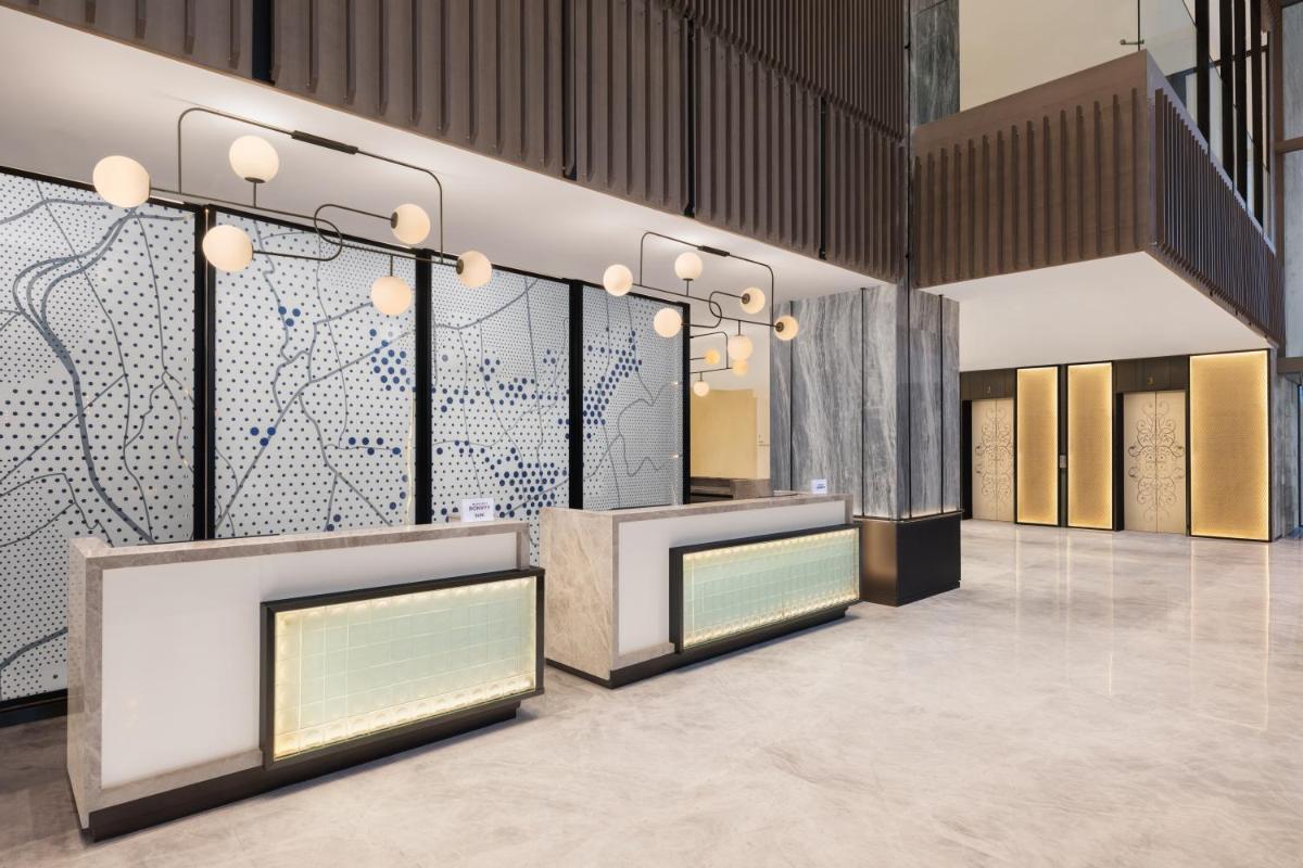 a lobby with two reception desks and a map on the wall at Le Meridien Ahmedabad in Ahmedabad
